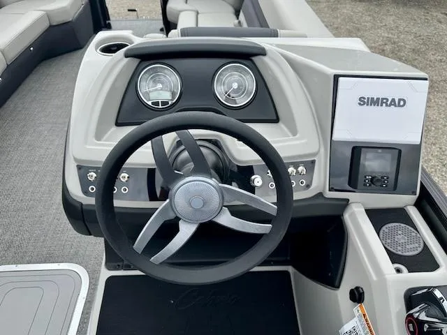 Slide: The Image of 2025 Barletta C24M boat dashboard with steering wheel and Simrad display. - 7