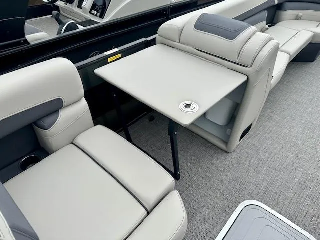 Slide: The Image of 2025 Barletta C24M boat interior with gray seating and foldable table. - 9