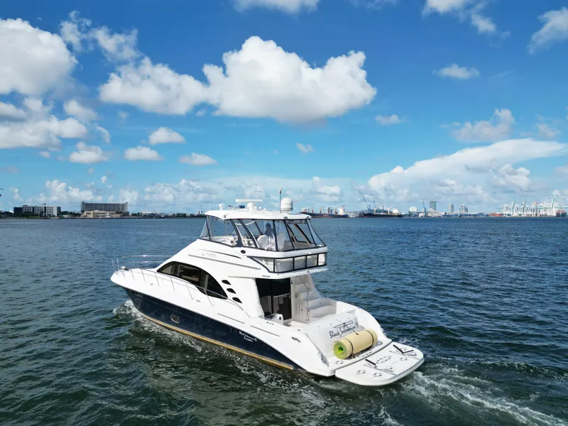 Slide: The Image of 2005 Sea Ray 58 Sedan Bridge yacht cruising on open water under a blue sky. - 10