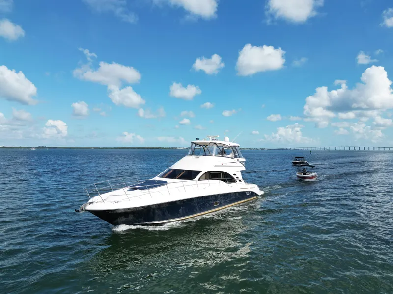 Slide: The Image of 2005 Sea Ray 58 Sedan Bridge yacht cruising on open water under a clear blue sky. - 11