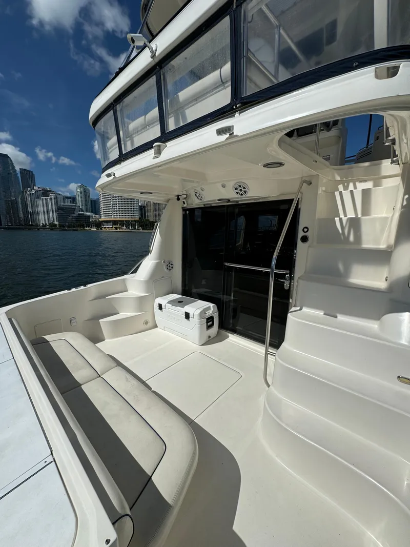 Slide: The Image of 2005 Sea Ray 58 Sedan Bridge yacht interior with seating and table, overlooking water. - 14