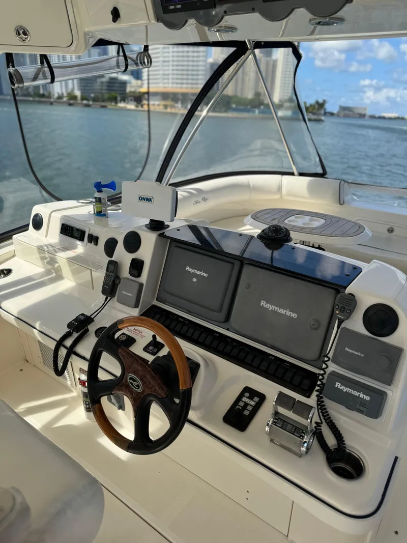 Slide: The Image of 2005 Sea Ray 58 Sedan Bridge helm with modern navigation equipment and waterfront view. - 20