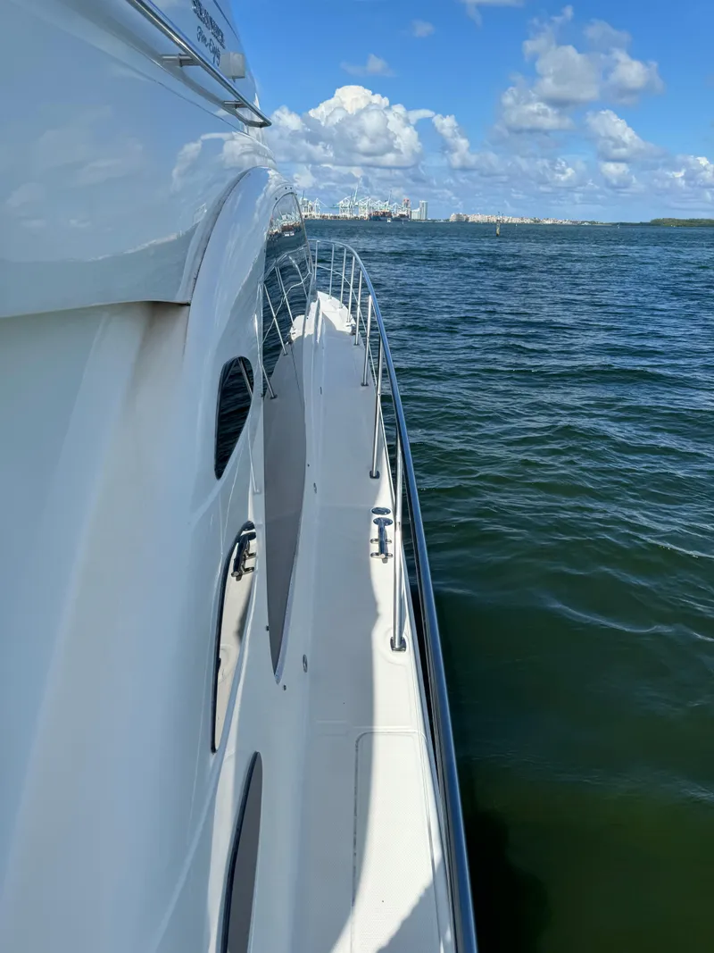 Slide: The Image of 2005 Sea Ray 58 Sedan Bridge yacht cruising on open water under a clear blue sky. - 23