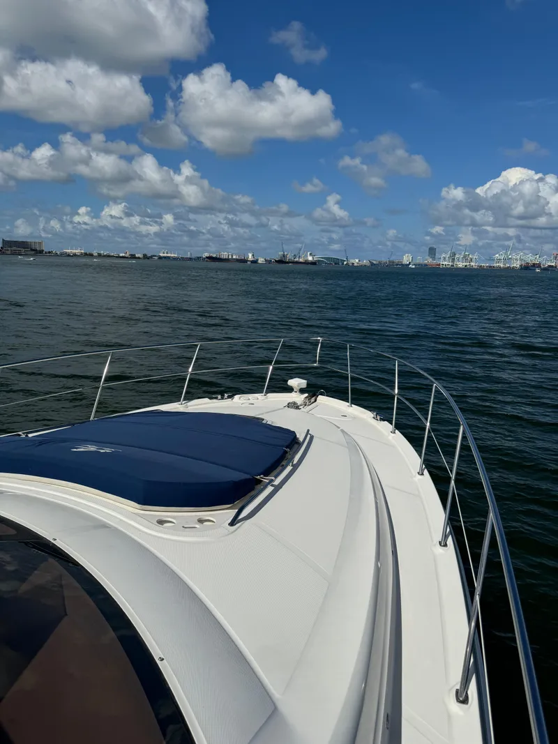 Slide: The Image of 2005 Sea Ray 58 Sedan Bridge yacht cruising on a sunny day with city skyline. - 25