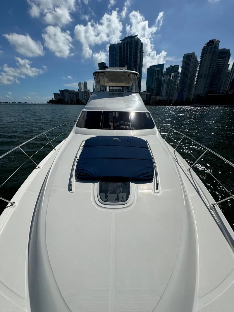 Slide: The Image of 2005 Sea Ray 58 Sedan Bridge yacht on water with city skyline backdrop. - 26
