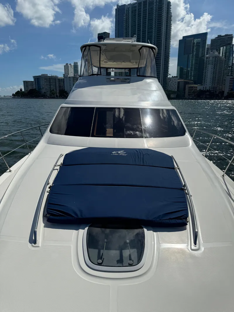 Slide: The Image of 2005 Sea Ray 58 Sedan Bridge yacht on water with city skyline backdrop. - 27