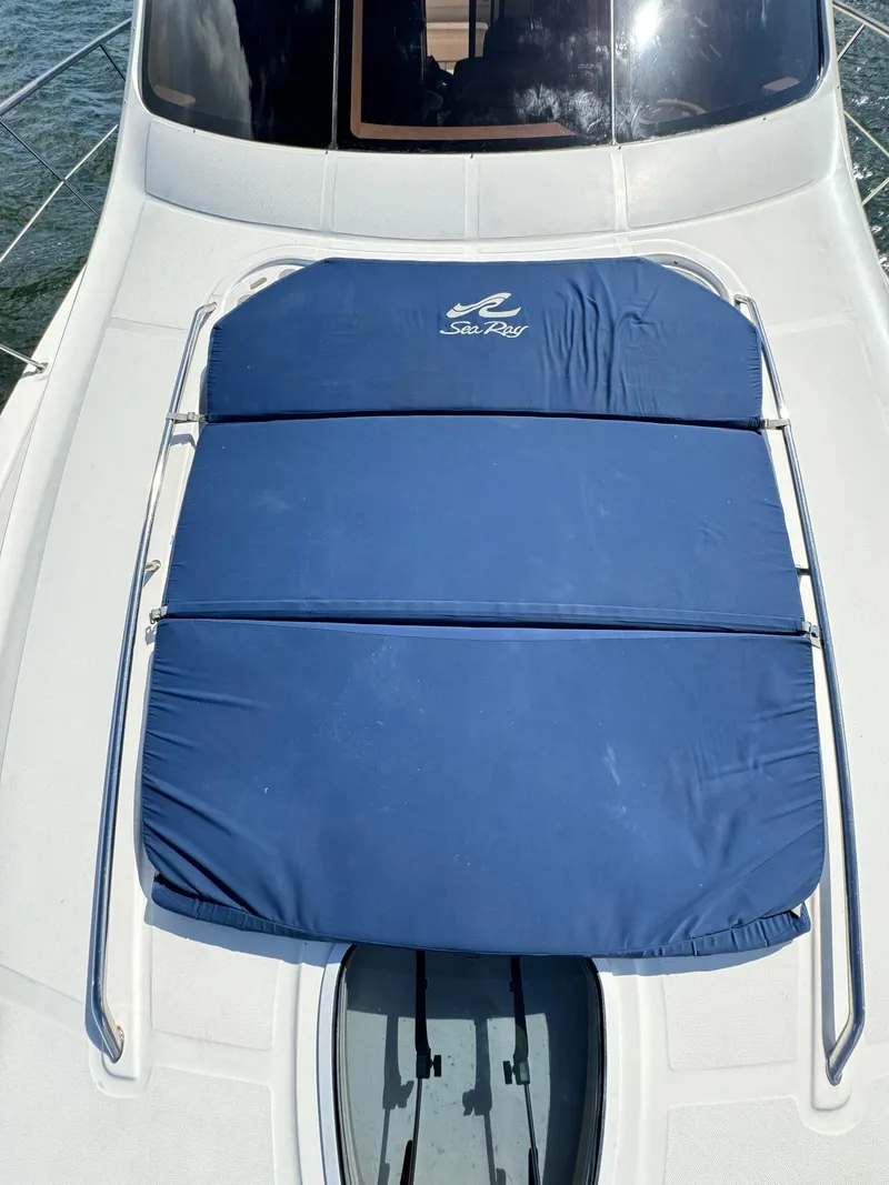 Slide: The Image of 2005 Sea Ray 58 Sedan Bridge with blue sunpad on deck. - 29