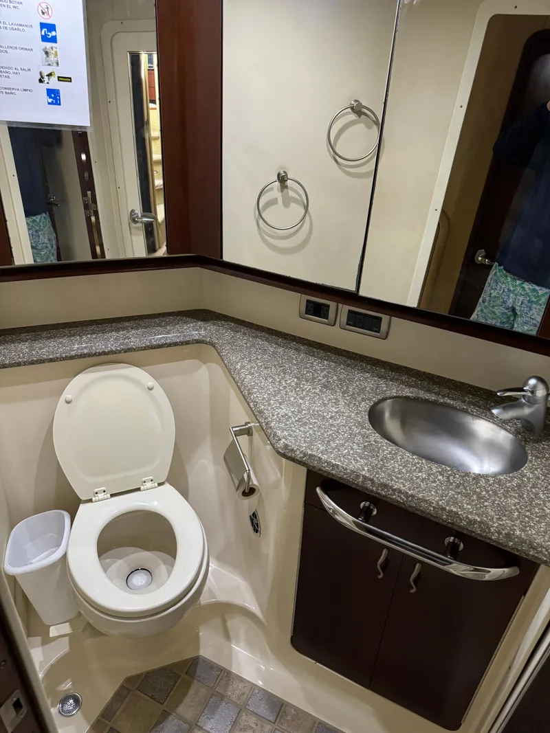 Slide: The Image of 2005 Sea Ray 58 Sedan Bridge bathroom with toilet, sink, and mirror. - 46