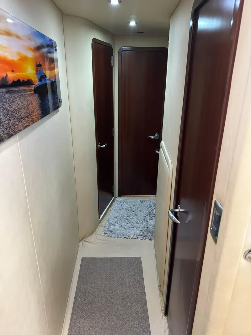 Slide: The Image of 2005 Sea Ray 58 Sedan Bridge interior hallway with artwork and wooden doors. - 47