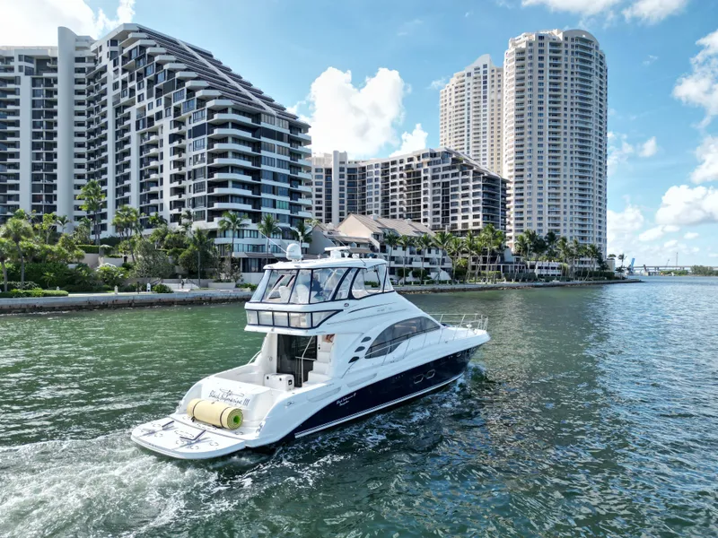Slide: The Image of 2005 Sea Ray 58 Sedan Bridge yacht cruising near waterfront skyscrapers. - 9