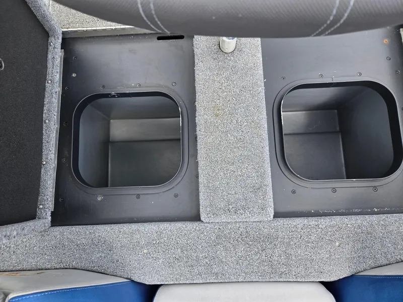 Slide: The Image of 2015 Skeeter FX 20 boat storage compartments with gray carpeted interior. - 23
