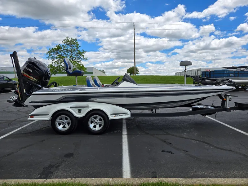 Slide: The Image of 2015 Skeeter FX 20 boat on trailer in parking lot under cloudy sky. - 4