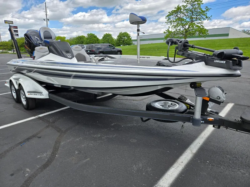 Slide: The Image of 2015 Skeeter FX 20 boat on trailer in parking lot, under cloudy sky. - 5