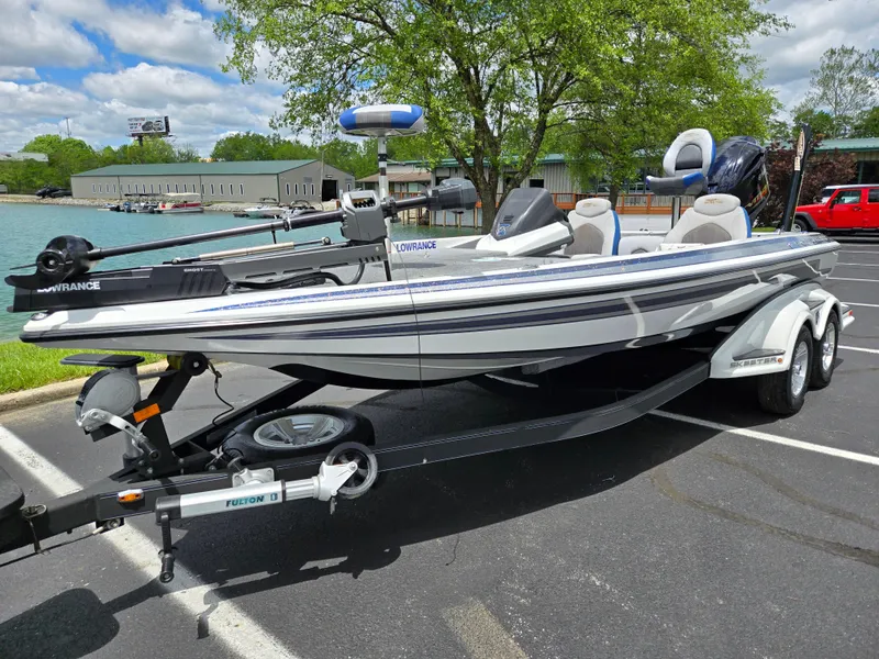 Slide: The Image of 2015 Skeeter FX 20 boat parked on a trailer in a scenic lakeside setting. - 9