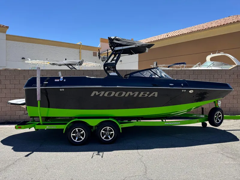 Slide: The Image of 2020 Moomba Max boat on trailer, black and green design, parked outdoors. - 0