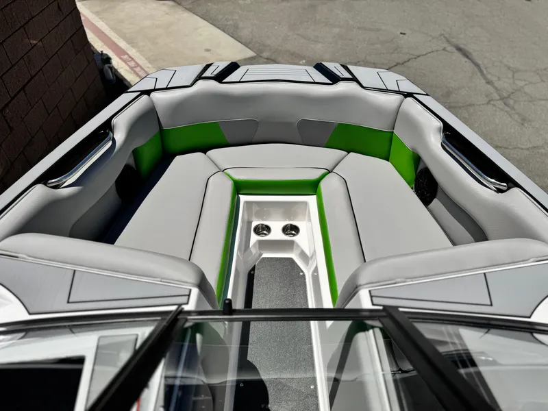 Slide: The Image of 2020 Moomba Max boat interior with gray and green seating, featuring cup holders. - 12