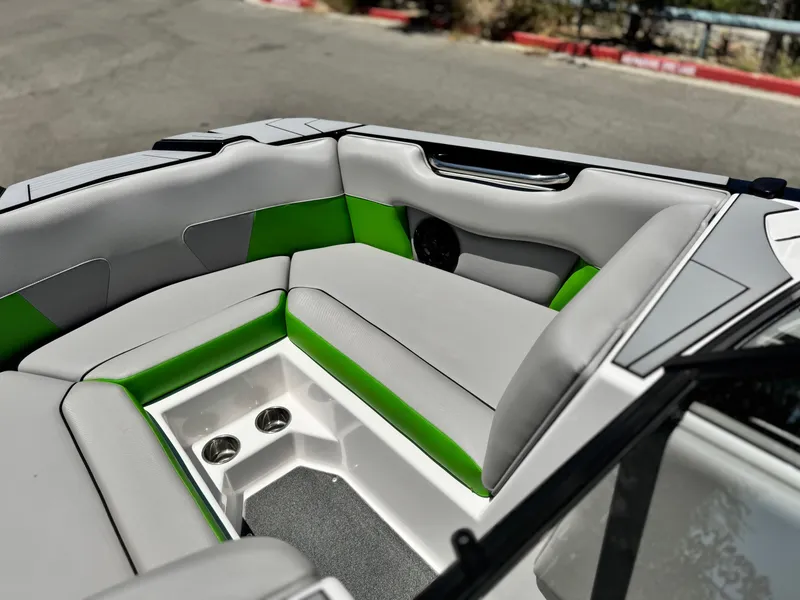 Slide: The Image of 2020 Moomba Max boat interior with gray and green seating, cup holders, and sleek design. - 14