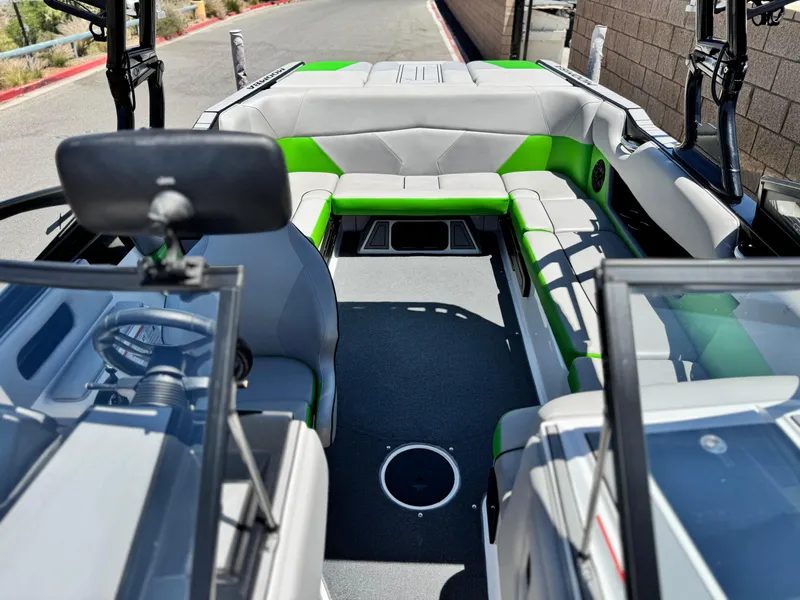 Slide: The Image of 2020 Moomba Max boat interior with gray and green seating, open layout. - 16