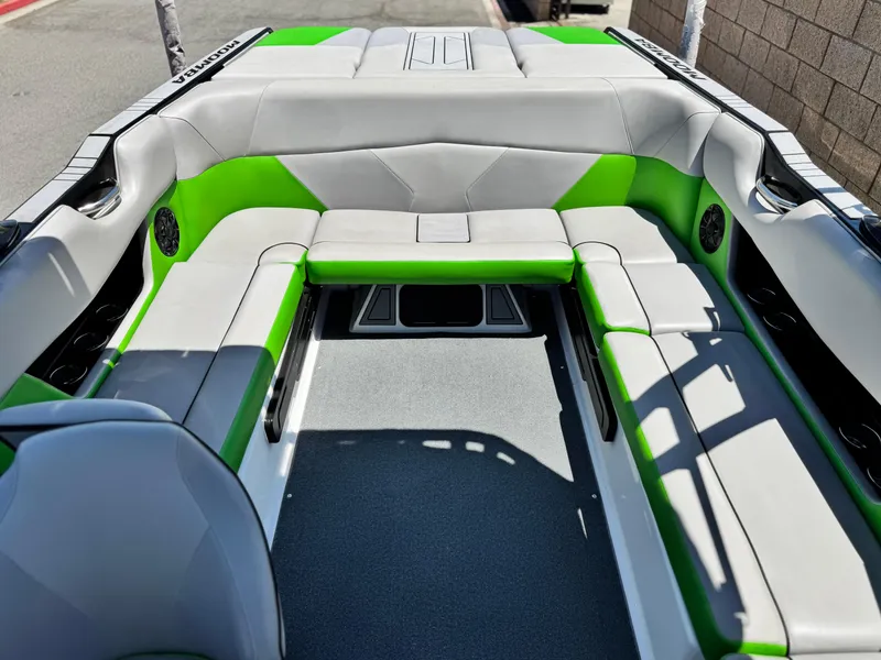 Slide: The Image of 2020 Moomba Max boat interior with gray and green seating, spacious layout. - 17