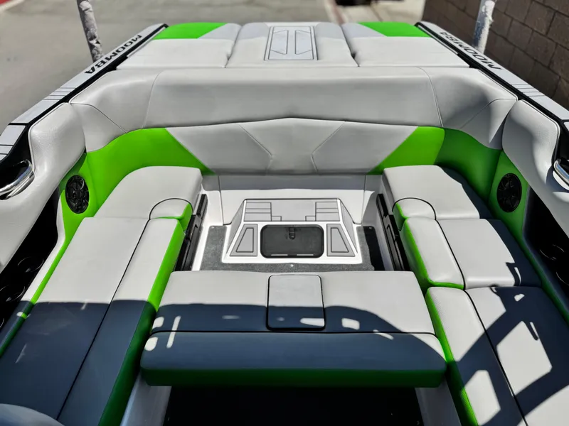Slide: The Image of 2020 Moomba Max boat interior with green and gray seating, featuring a spacious layout. - 18