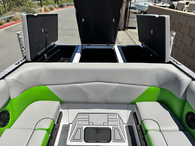 Slide: The Image of 2020 Moomba Max boat interior with open storage compartments and green-gray seating. - 19