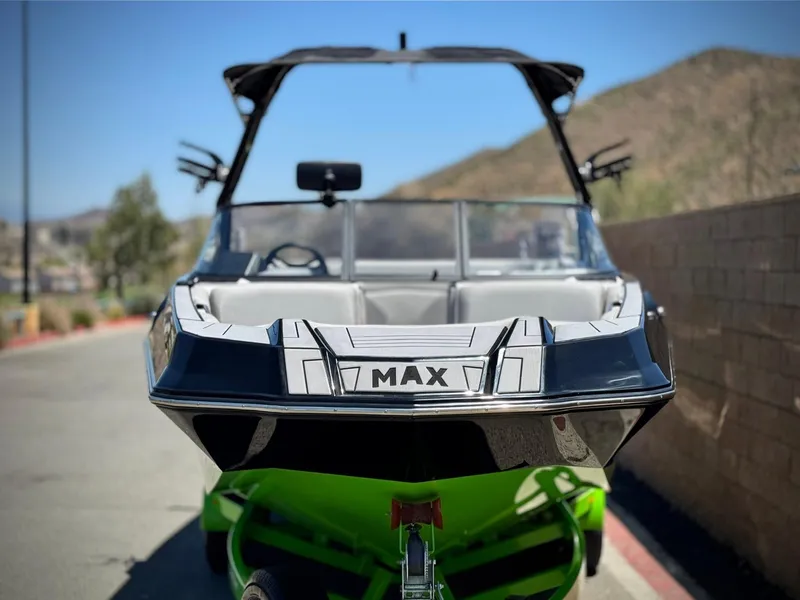 Slide: The Image of 2020 Moomba Max boat on trailer, parked outdoors with scenic background. - 2