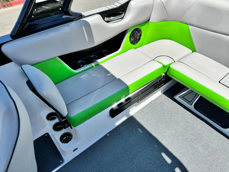 Slide: The Image of 2020 Moomba Max boat interior with green and gray seating, featuring cup holders and speaker. - 21