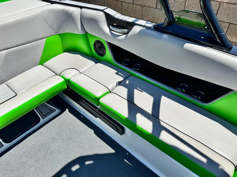 Slide: The Image of 2020 Moomba Max boat interior with green and gray seating, speaker, and sleek design. - 22