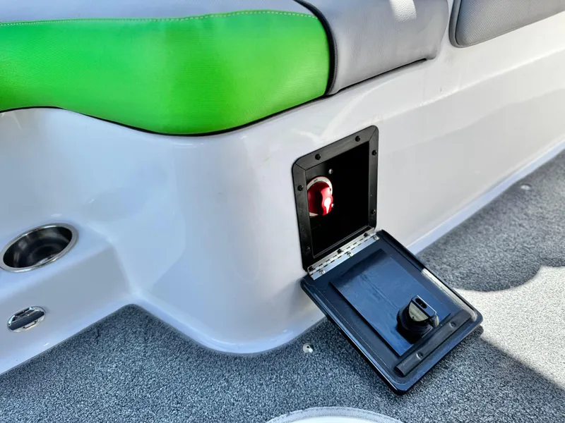 Slide: The Image of 2020 Moomba Max boat interior with green and gray seating, open storage compartment. - 27