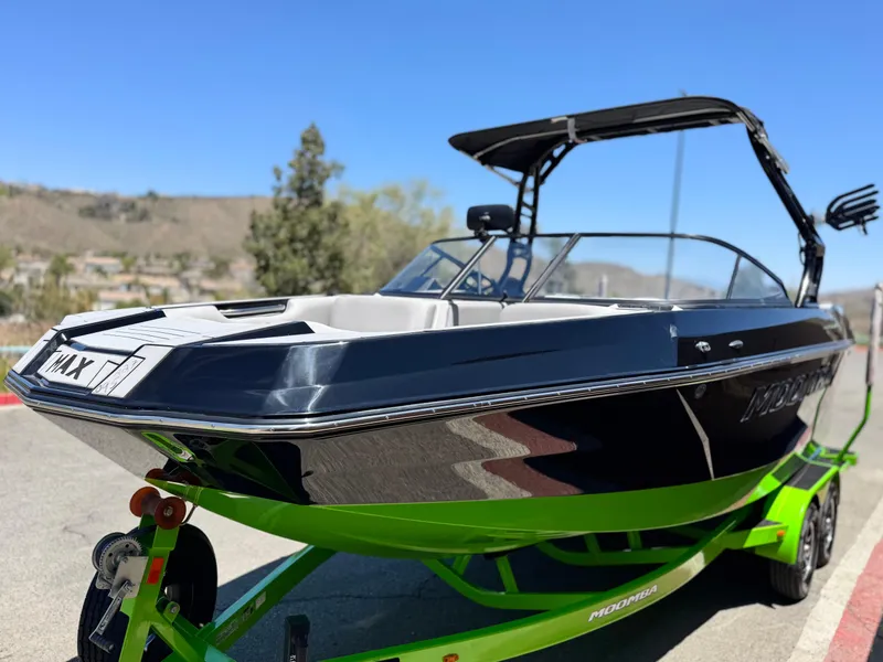 Slide: The Image of 2020 Moomba Max boat on a vibrant green trailer, parked outdoors. - 3