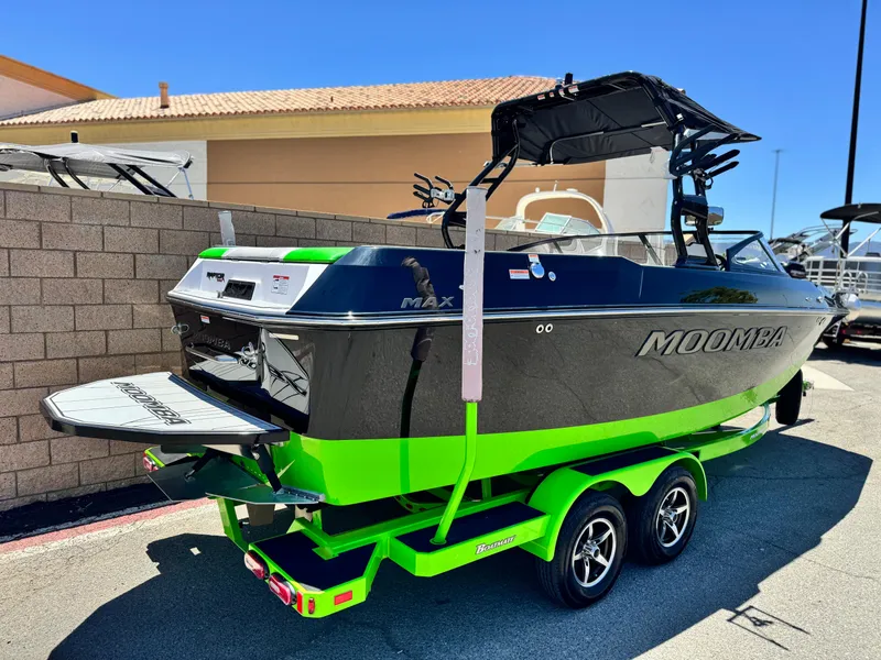 Slide: The Image of 2020 Moomba Max boat with vibrant green accents on a trailer, parked outdoors. - 5