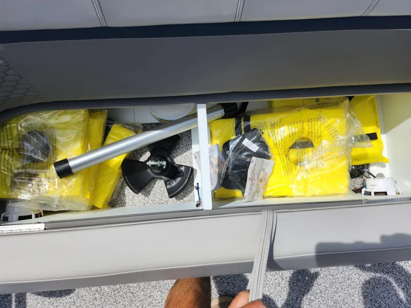 Slide: The Image of Storage compartment in 2023 Qwest 8522 Pro Family Fish boat with safety gear and accessories. - 11