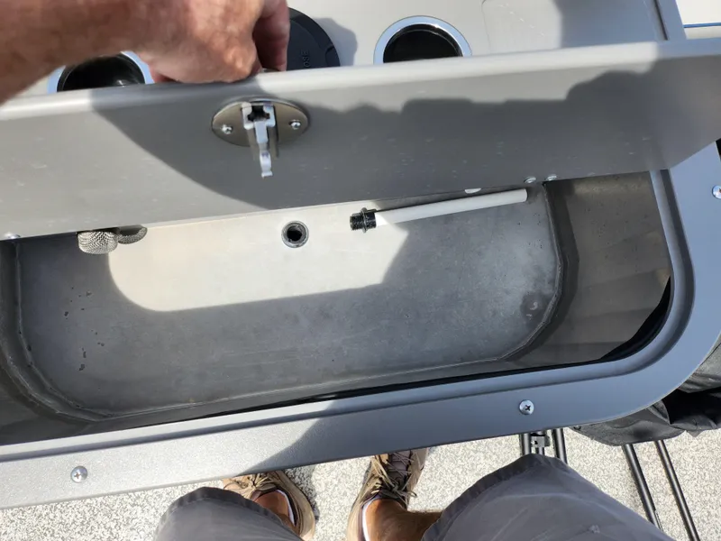 Slide: The Image of 2023 Qwest 8522 Pro Family Fish boat compartment with open lid and cup holders. - 22