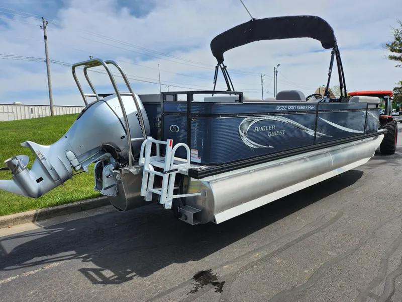 Slide: The Image of 2023 Qwest 8522 Pro Family Fish pontoon boat with outboard motor, parked on pavement. - 3