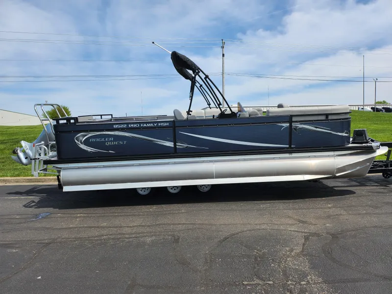 Slide: The Image of 2023 Qwest 8522 Pro Family Fish pontoon boat on a trailer, parked outdoors. - 4