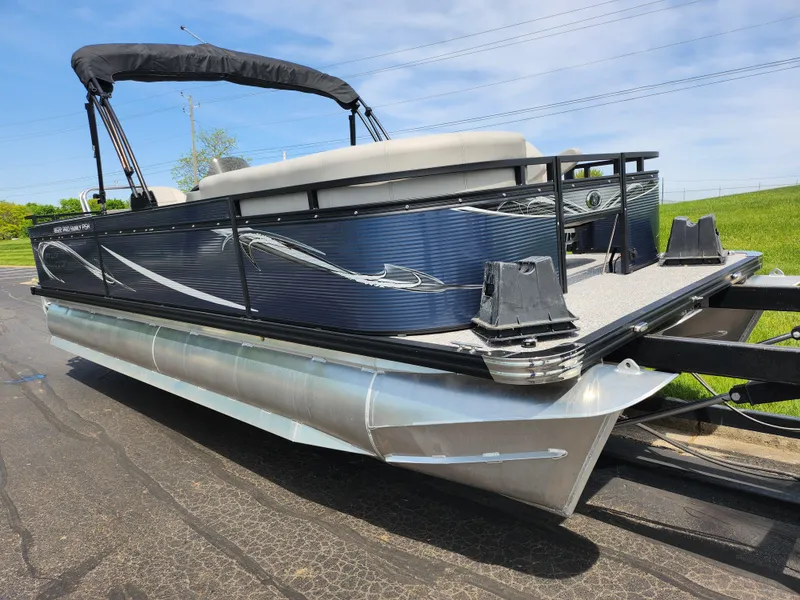 Slide: The Image of 2023 Qwest 8522 Pro Family Fish pontoon boat on trailer, sleek design, sunny day. - 5