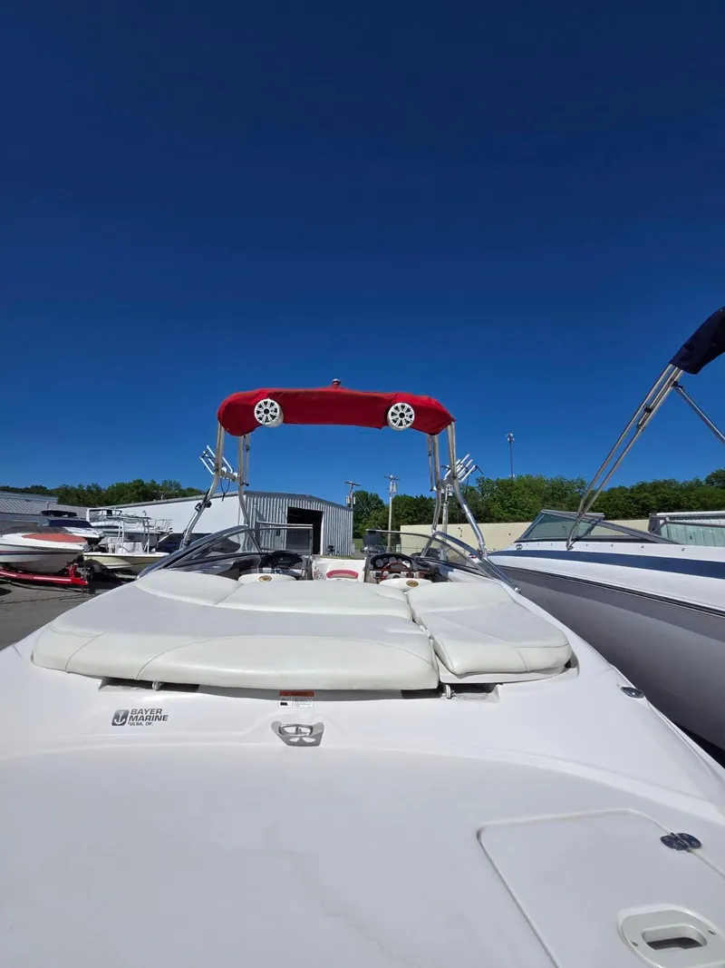 Slide: The Image of 2005 Four Winns 200 Horizon SS boat with red canopy, docked under clear blue sky. - 10