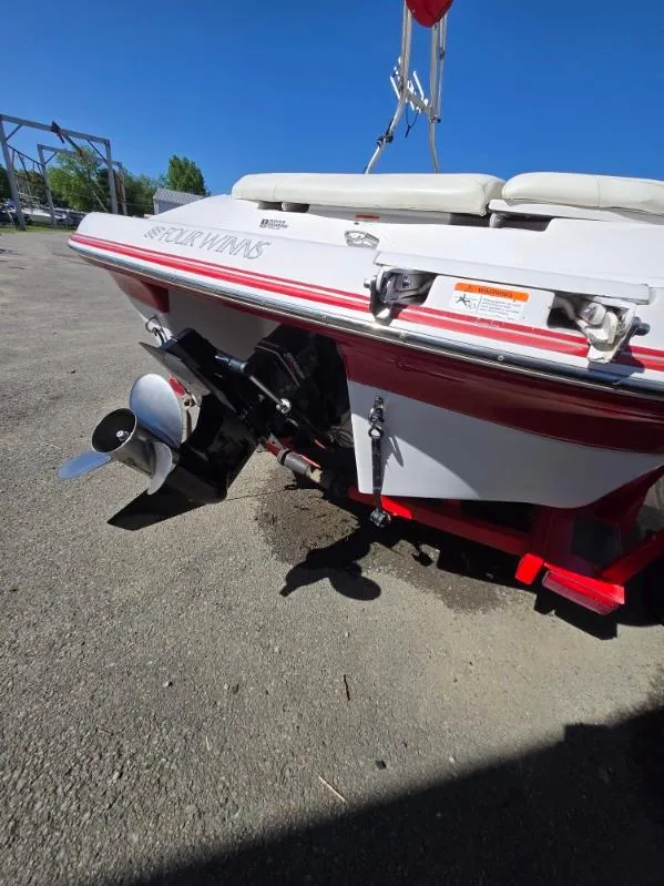 Slide: The Image of 2005 Four Winns 200 Horizon SS boat, rear view with outboard motor, parked on pavement. - 11