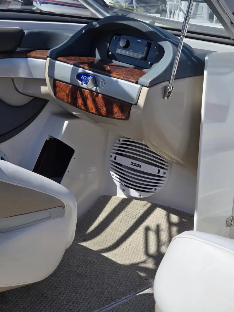 Slide: The Image of 2005 Four Winns 200 Horizon SS boat interior with wood accents and speaker system. - 12