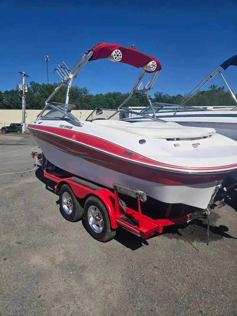 Slide: The Image of 2005 Four Winns 200 Horizon SS boat on red trailer, parked outdoors. - 2
