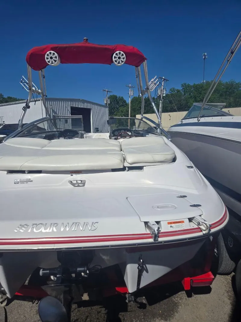 Slide: The Image of 2005 Four Winns 200 Horizon SS boat with red canopy, docked outdoors. - 4