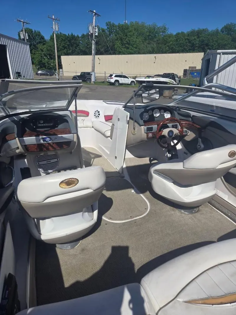 Slide: The Image of 2005 Four Winns 200 Horizon SS boat interior with dual steering wheels and white seating. - 5