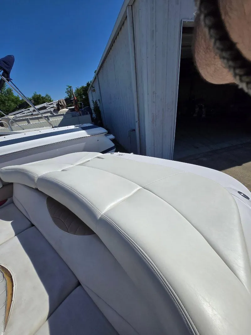 Slide: The Image of 2005 Four Winns 200 Horizon SS boat with white upholstery near a garage. - 7