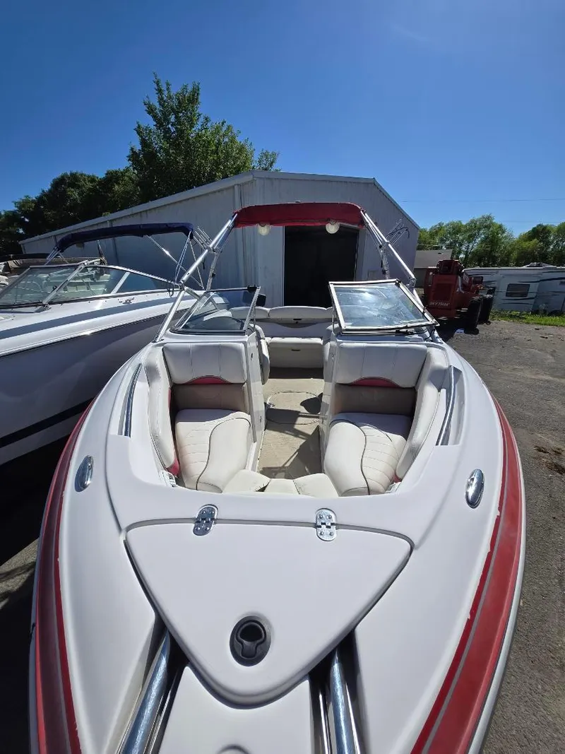 Slide: The Image of 2005 Four Winns 200 Horizon SS boat with red accents, docked outdoors under clear blue sky. - 8