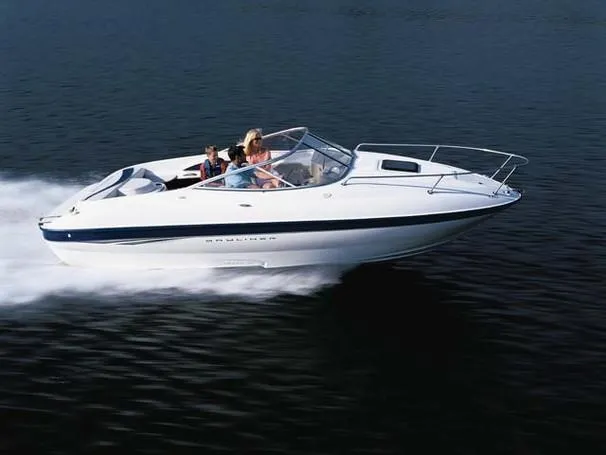 Slide: The Image of 2003 Bayliner 212 boat cruising on open water with passengers onboard. - 12