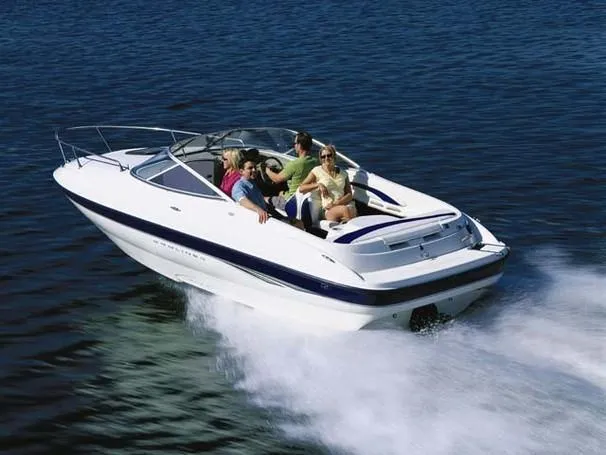 Slide: The Image of 2003 Bayliner 212 speedboat cruising on open water with passengers enjoying the ride. - 13