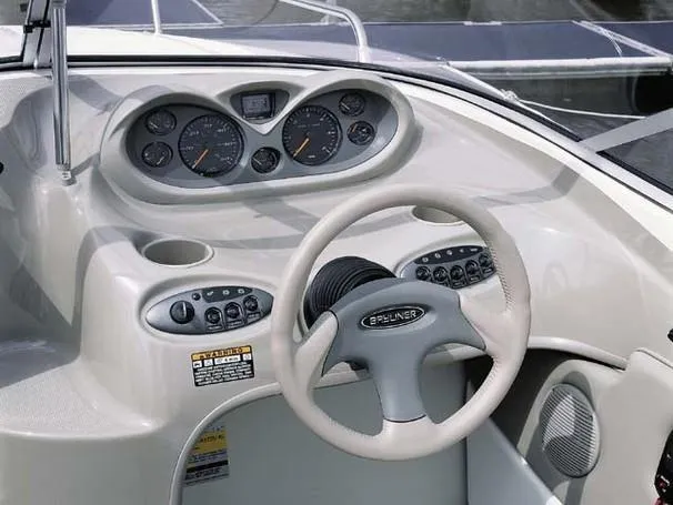 Slide: The Image of 2003 Bayliner 212 boat dashboard with steering wheel and instrument panel. - 14