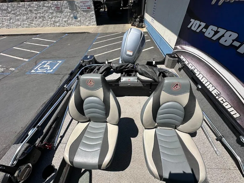 Slide: The Image of 2020 Alumacraft Classic 165 boat interior with two gray seats in a parking lot. - 11