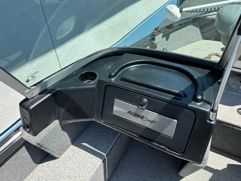Slide: The Image of 2020 Alumacraft Classic 165 boat dashboard with storage compartment and cup holder. - 17
