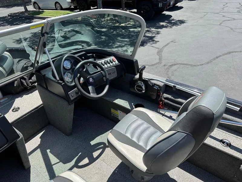 Slide: The Image of 2020 Alumacraft Classic 165 boat interior with steering wheel and seating. - 18